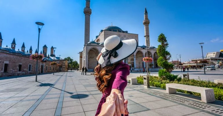 Women tourists holding man's hand and leading him to mosque in k